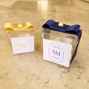 Caixinha acrílica decorada com o monograma dos noivos nas cores azul e dourado com amêncoad açucaradas